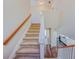 Carpeted staircase with wood banister and white accents overlooking hardwood floors at 3780 Baxley Pine Trl, Suwanee, GA 30024