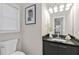 Bathroom boasts an elegant vanity with granite countertop, a modern light fixture, and stylish framed art on the wall at 735 Ponce De Leon Ne Pl, Atlanta, GA 30306