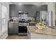 Open kitchen featuring stainless steel appliances, granite countertops, gray cabinets and tile backsplash at 735 Ponce De Leon Ne Pl, Atlanta, GA 30306