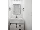 Bathroom vanity with a modern black faucet, white countertop, a square mirror, and a barn door cabinet at 2423 Melinda Ne Dr, Atlanta, GA 30345