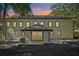 Rear view of home with beautiful sunset, manicured backyard, and exterior lighting at 2423 Melinda Ne Dr, Atlanta, GA 30345
