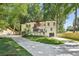 Charming home with black framed windows and a modern two-car garage, surrounded by lush greenery and a long driveway at 2423 Melinda Ne Dr, Atlanta, GA 30345