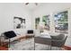 Bright home office featuring hardwood floors, modern art, and natural light from multiple windows overlooking lush greenery at 2423 Melinda Ne Dr, Atlanta, GA 30345