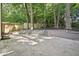 Concrete backyard patio with attractive retaining wall, trees, and lush landscaping at 2423 Melinda Ne Dr, Atlanta, GA 30345