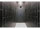 Modern shower with vertically stacked dark tile and white penny tile floor at 2423 Melinda Ne Dr, Atlanta, GA 30345
