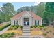 Attractive clubhouse featuring symmetrical design, tan exterior, and decorative landscaping at 3466 Northfield Nw Way, Kennesaw, GA 30144