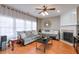 Cozy living room with hardwood floors, a ceiling fan, and a decorative fireplace at 3466 Northfield Nw Way, Kennesaw, GA 30144