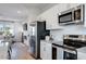 Kitchen with stainless steel appliances, white cabinets, and view into living room at 5841 Schelton Se Pl, Mableton, GA 30126