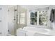 Clean bathroom with a glass shower, soaking tub, and a large window with a view at 1048 Standard Ne Dr, Atlanta, GA 30319