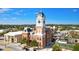 Aerial view of historic clock tower building with brick facade, decorative trim, and surrounding cityscape with blue sky at 13238 Tolstoy, Covington, GA 30014