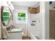 Bathroom featuring a shower-tub combo, vanity with sink, and window with natural light at 4027 Finch Sw Rd, Powder Springs, GA 30127