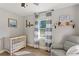 Bedroom featuring neutral walls, a crib, a gray chair, and blue and white curtains at 4027 Finch Sw Rd, Powder Springs, GA 30127