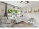 Bright Bedroom featuring a gray chair, dresser, and mountain themed artwork at 4027 Finch Sw Rd, Powder Springs, GA 30127