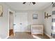 Sunlit Bedroom featuring neutral walls and carpet, white trim, and a white crib at 4027 Finch Sw Rd, Powder Springs, GA 30127