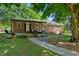 Charming brick home with covered porch, outdoor seating, and a picturesque walkway at 4027 Finch Sw Rd, Powder Springs, GA 30127