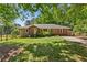 Charming brick home featuring a lush green lawn and mature trees offering plenty of shade at 4027 Finch Sw Rd, Powder Springs, GA 30127