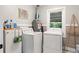 Functional laundry room with washer, dryer, storage, and natural light at 4027 Finch Sw Rd, Powder Springs, GA 30127