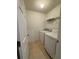 A laundry room features a washing machine, a dryer, tile flooring, and wire shelving at 1530 Viero Dr, Lawrenceville, GA 30044