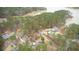 Aerial view of a home nestled among mature trees near a body of water; includes an outbuilding and a long driveway at 4770 Hilltop Nw Dr, Acworth, GA 30101