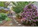 Stone pathway winds through lush garden featuring colorful flowers and a charming outdoor structure at 4770 Hilltop Nw Dr, Acworth, GA 30101