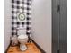 Half bath features buffalo check wallpaper and rustic farmhouse charm at 4770 Hilltop Nw Dr, Acworth, GA 30101