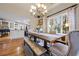 Bright dining room features a rustic wood table, chandelier, and large window with backyard views at 4770 Hilltop Nw Dr, Acworth, GA 30101