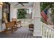 Inviting front porch with rocking chairs, an American flag, and a gray painted wood porch at 4770 Hilltop Nw Dr, Acworth, GA 30101