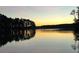 Scenic lake view at sunset with golden light reflecting on the calm water and silhouetted trees at 4770 Hilltop Nw Dr, Acworth, GA 30101