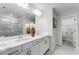 Bright bathroom features dual sinks, white cabinetry, decorative vases, and a glass-enclosed shower at 5837 Schelton Se Pl, Mableton, GA 30126