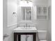 Well-lit bathroom with a dark vanity, stylish light fixture, framed mirror and plenty of storage at 2288 Street Deville Ne, Atlanta, GA 30345