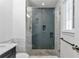 Bathroom featuring a glass shower with gray tile, pebble flooring, marble accents, and modern fixtures at 2288 Street Deville Ne, Atlanta, GA 30345