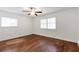 Bright, empty bedroom with hardwood floors, two windows and a ceiling fan at 2288 Street Deville Ne, Atlanta, GA 30345