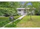 Charming single-Gathering home featuring a manicured lawn, mature trees, and a lovely walkway to the front door at 2288 Street Deville Ne, Atlanta, GA 30345