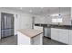 Bright kitchen featuring white cabinetry, stainless steel appliances, an island, and black granite countertops at 2288 Street Deville Ne, Atlanta, GA 30345