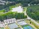 Exceptional aerial view showcases townhomes, tennis courts, and a picturesque pond surrounded by a lush golf course at 329 Lakebridge Xing, Canton, GA 30114