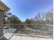Balcony view with metal railing overlooking trees and a distant lake at 329 Lakebridge Xing, Canton, GA 30114