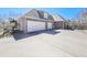 A spacious driveway leads to the three-car garage of this brick home at 329 Lakebridge Xing, Canton, GA 30114