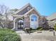 Charming brick and stucco home with an arched window, double front doors with wreath decorations at 329 Lakebridge Xing, Canton, GA 30114