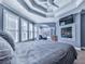 This main bedroom includes a fireplace, a tray ceiling with fan, and multiple windows, creating a cozy and bright space at 329 Lakebridge Xing, Canton, GA 30114