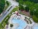 Overhead view of a community pool with water slide and seating area with lush landscaping at 329 Lakebridge Xing, Canton, GA 30114