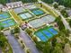 An overhead view of multiple tennis courts with vibrant colors, adjacent to community parking at 329 Lakebridge Xing, Canton, GA 30114