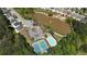 Overhead view showcases community amenities: a pond, pool, tennis courts, and parking in a suburban setting at 5819 Rue Chase Way, Tucker, GA 30084