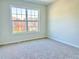 Bright bedroom featuring neutral carpeting and a large window with a neighborhood view at 5819 Rue Chase Way, Tucker, GA 30084