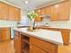 Close up on large kitchen island with seating, wooden cabinets, and white countertops at 5819 Rue Chase Way, Tucker, GA 30084