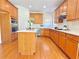 Open kitchen with hardwood floors, wood cabinets, stainless steel appliances, and center island at 5819 Rue Chase Way, Tucker, GA 30084