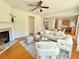 Bright living room featuring a fireplace, ceiling fan, and an open floor plan into the kitchen at 5819 Rue Chase Way, Tucker, GA 30084