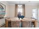 Dining area with a rustic wooden table, six upholstered chairs, and elegant curtains at 146 Silver Leaf Trce, Douglasville, GA 30134