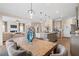 Open-concept dining room and kitchen with a large wooden table, upholstered chairs, and stylish pendant lighting at 146 Silver Leaf Trce, Douglasville, GA 30134