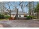 Charming home featuring a brick chimney, quaint porch, and light-colored exterior, nestled in a wooded lot at 1849 S Columbia Place, Decatur, GA 30032