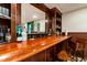 Basement bar area with dark wood, a mirror, and seating for entertaining at 4048 Sandy Branch Ne Dr, Buford, GA 30519